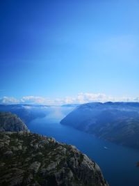 Scenic view of sea and mountains against blue sky