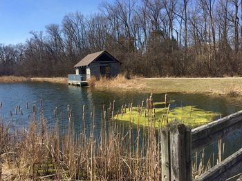 House by lake against trees