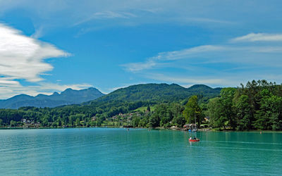 Scenic view of sea and mountains against blue sky