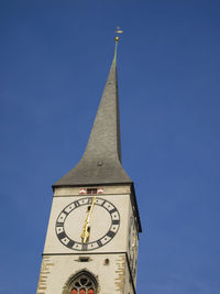 Low angle view of clock tower against clear blue sky