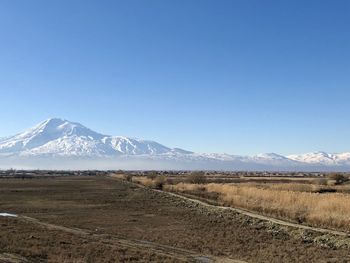 Scenic view of snowcapped mountains against blue sky