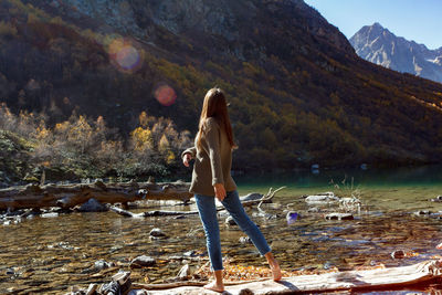 Nice girl traveler on red autumn lake