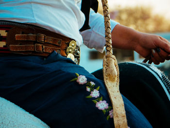 Midsection of people holding cross