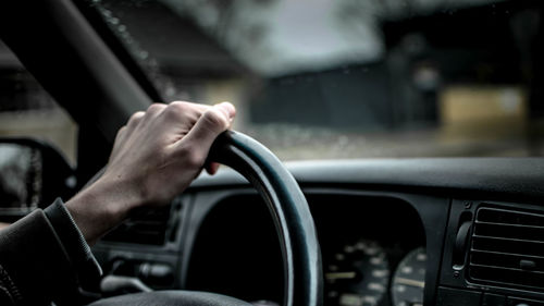 Cropped image of man driving car