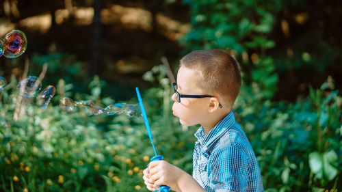 Portrait of young boy blowing bubbles