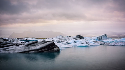 Scenic view of frozen lake against sky during winter