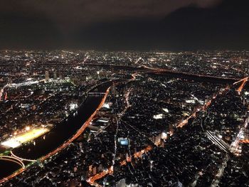 High angle view of illuminated city against sky at night