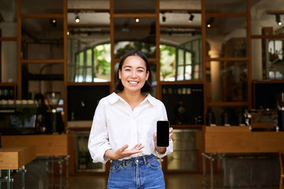 Portrait of young woman standing in store