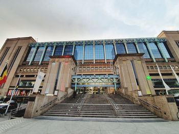 Low angle view of steps amidst buildings against sky