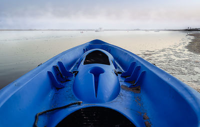 Close-up of boat on sea shore against sky