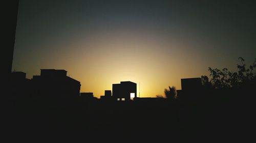 Silhouette cityscape against sky during sunset
