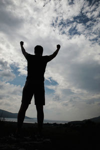 Rear view of silhouette man standing against sky