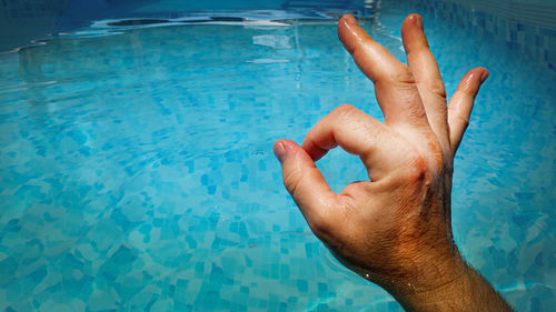 Midsection of man swimming in pool