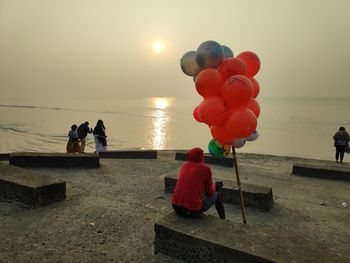 Rear view of woman holding balloons