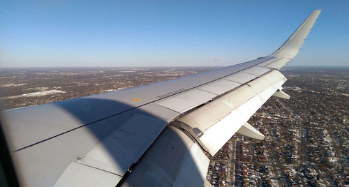 Airplane wing against blue sky