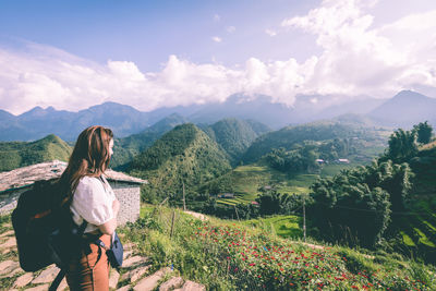 Woman standing on mountain against sky