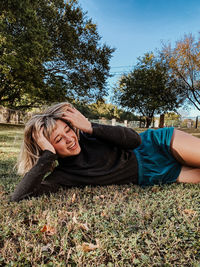 Portrait of smiling woman lying down on field