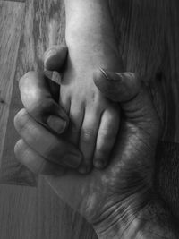 Close-up of father holding baby hand