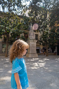 Rear view of woman standing against trees