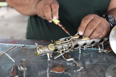 Midsection of man working on metal