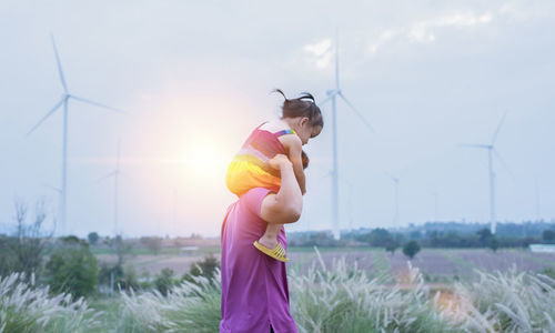 Rear view of woman standing on field