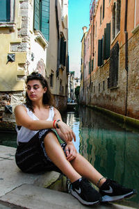 Portrait of young woman sitting in city