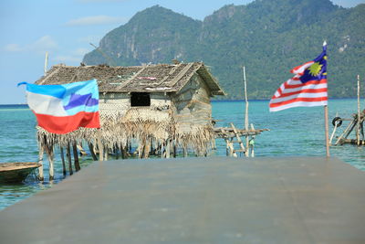 Flag by sea against mountains