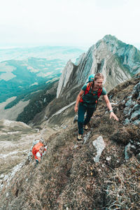 People on rocks against mountains