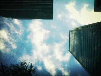 Low angle view of modern building against cloudy sky