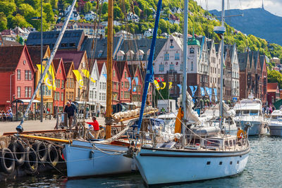 Boats moored in canal by buildings in city