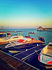 Boats in sea at sunset