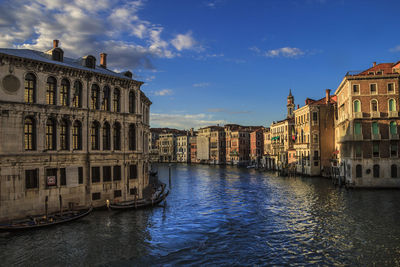 View of buildings in city against cloudy sky