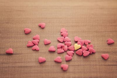 High angle view of heart shape candies on wooden table