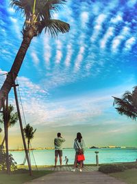 People enjoying at beach against sky