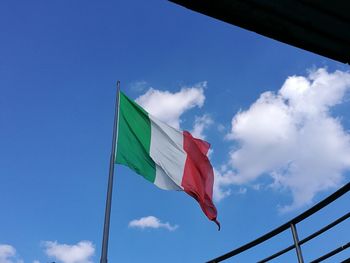 Low angle view of flag against blue sky