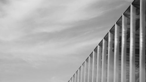 High section of modern building against cloudy sky