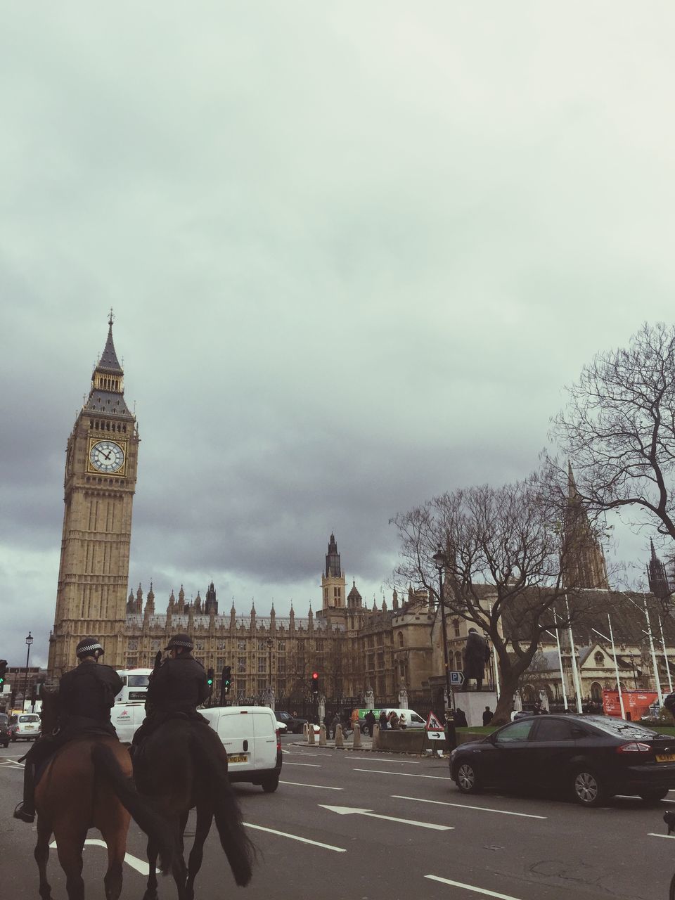 architecture, building exterior, built structure, sky, city, transportation, men, car, street, land vehicle, city life, cloud - sky, road, famous place, person, travel, lifestyles, capital cities, travel destinations