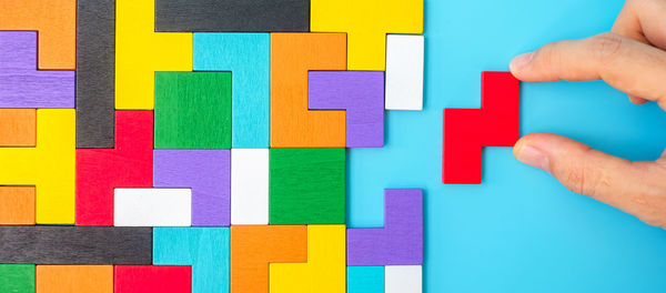 Midsection of child holding multi colored paper hand