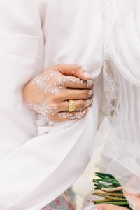 Midsection of woman holding wedding rings