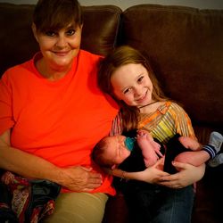 Portrait of family with cute girl sitting on sofa at home