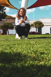 Rear view of woman sitting on grassy field