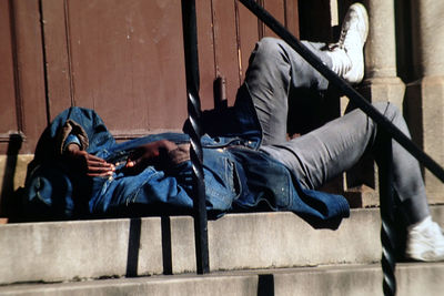 Side view of man lying on steps in city