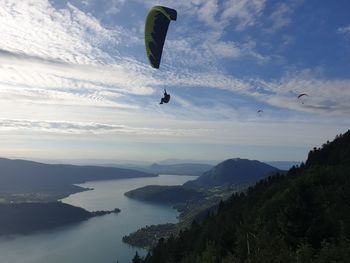 People paragliding over sea against sky