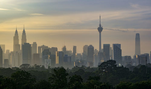 Buildings in city against sky during sunset