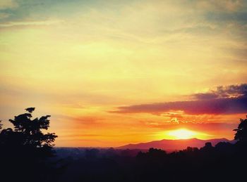 Scenic view of silhouette mountains against orange sky