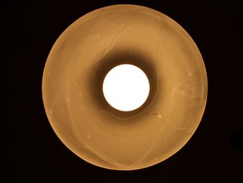 Directly below shot of illuminated light bulb against black background