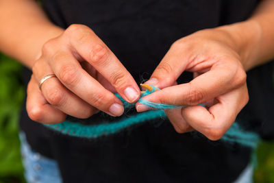 The woman knits woolen clothes. knitting needles. close-up. natural wool