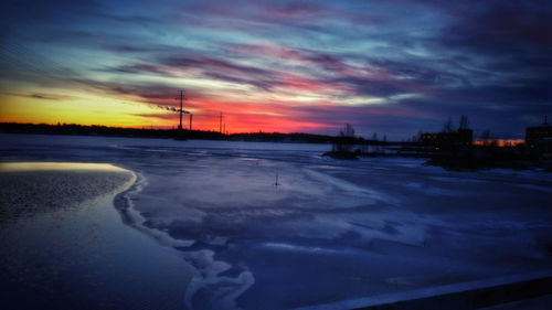 Snow covered landscape against dramatic sky