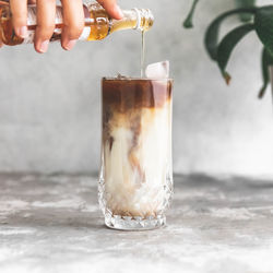 Midsection of person pouring coffee in glass