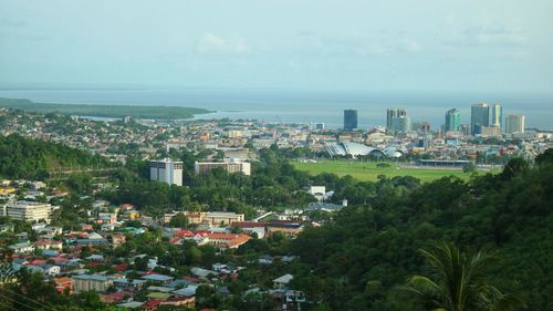 High angle view of cityscape by sea against sky